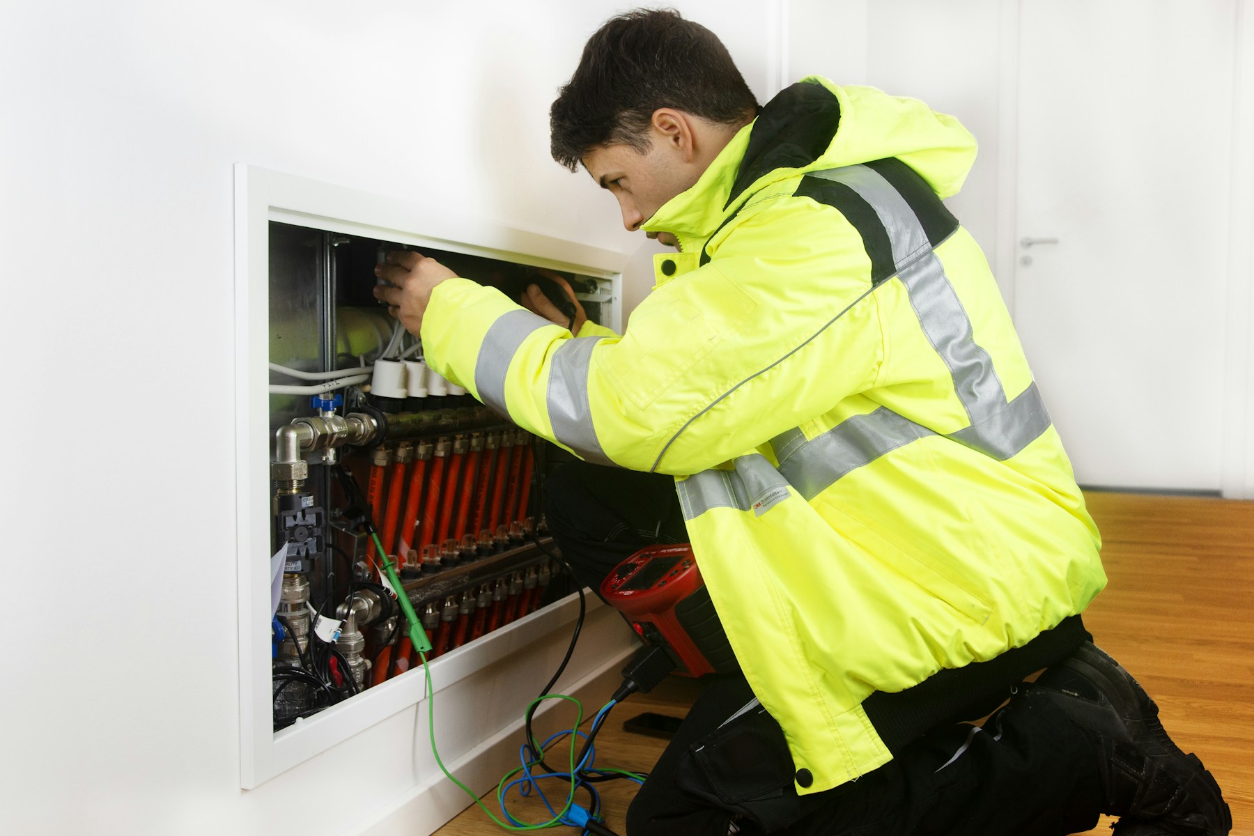 HVAC technician working on a hydronic heating manifold